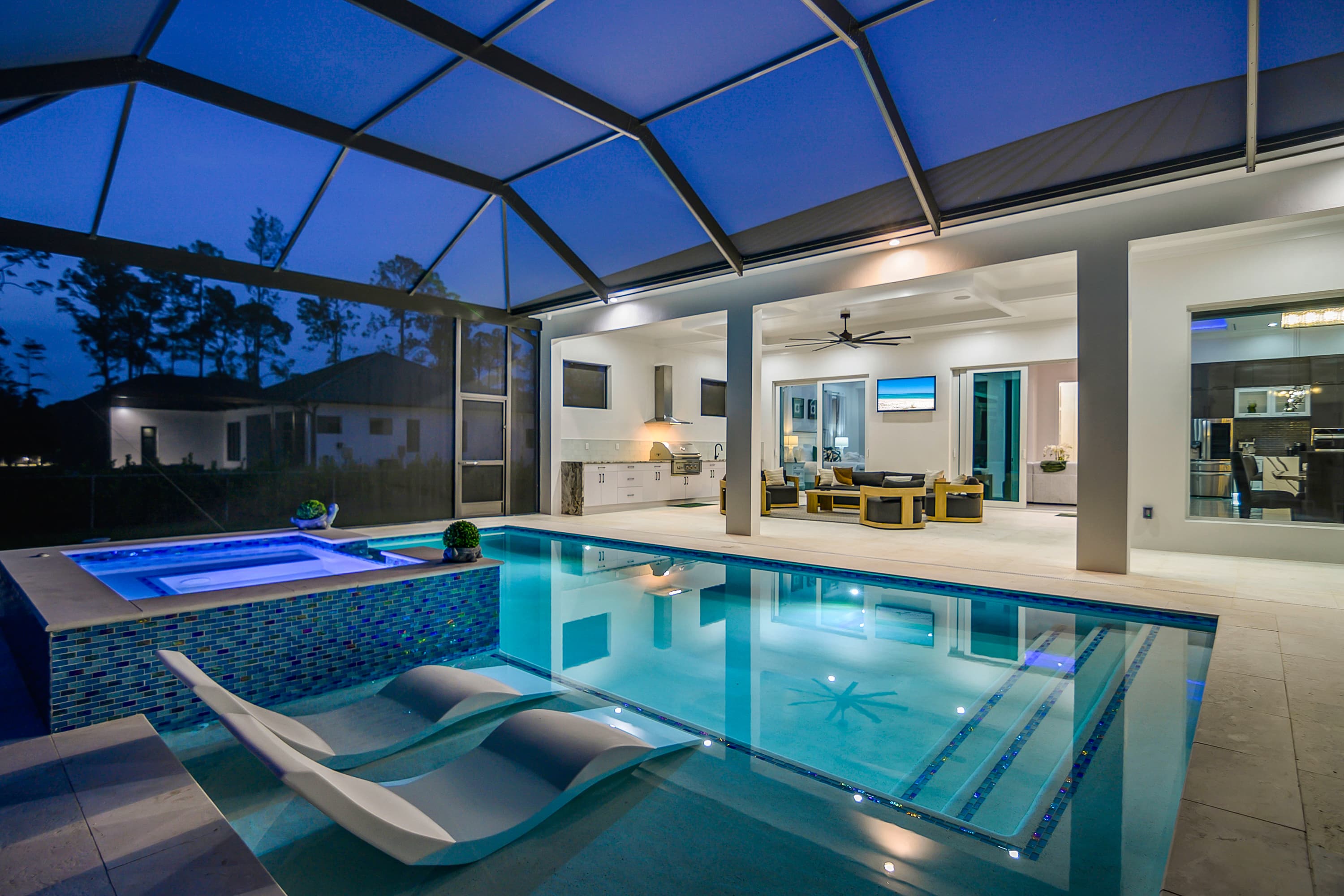 Clearest wide angle view of pool and elevated spa under screened enclosure at twilight